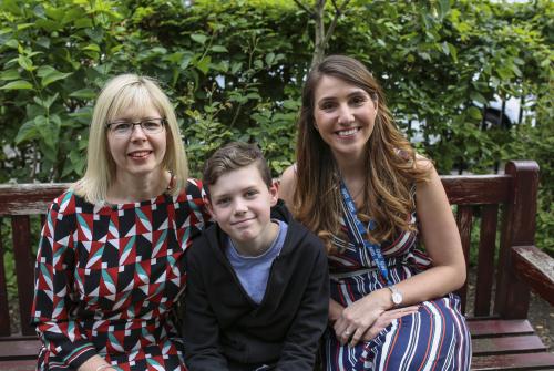 Oscar, his mum and Dr Hadji-Michael on a bench at GOSH